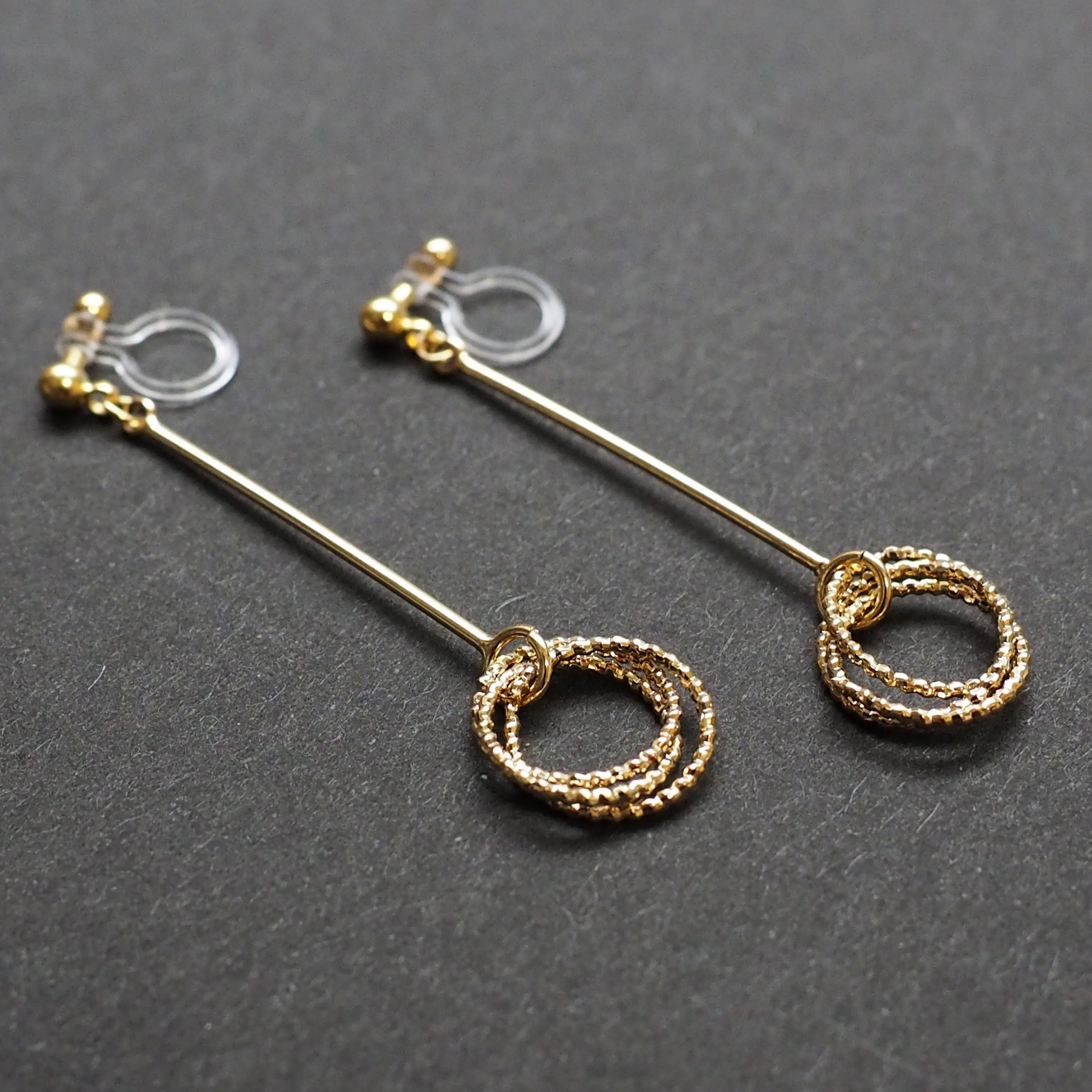 Textured triple hoop clip on earrings ( Gold tone )
